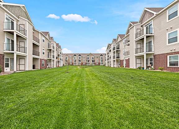 Courtyard lawn between multi story residential buildings at Copper Creek Homes Apartments, Kansas, 67101