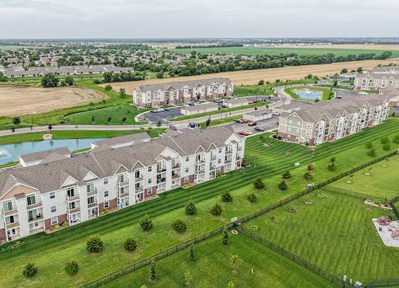Aerial view of apartment buildings and green space at Copper Creek Homes Apartments, Maize
