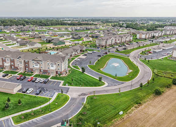 Aerial view of residential community with pond at Copper Creek Homes Apartments, Kansas