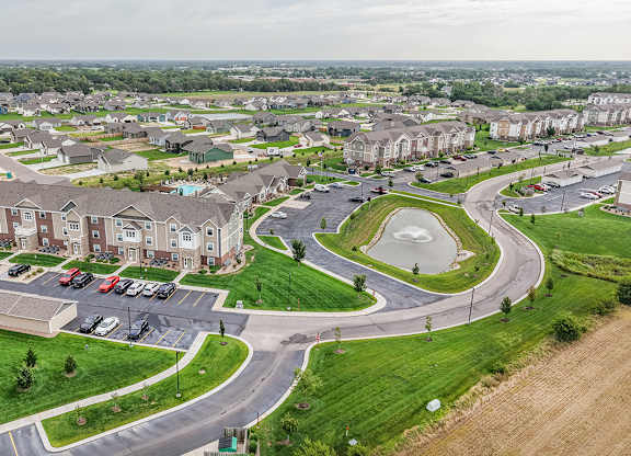 Aerial view of residential community with retention pond at Copper Creek Homes Apartments, Kansas, 67101