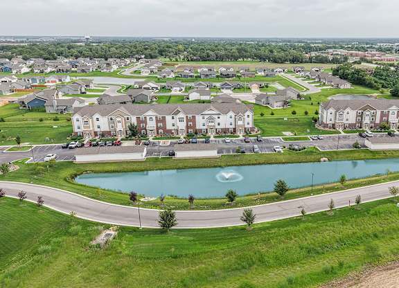 Aerial view of residential neighborhood with retention pond at Copper Creek Homes Apartments, Maize, KS 67101