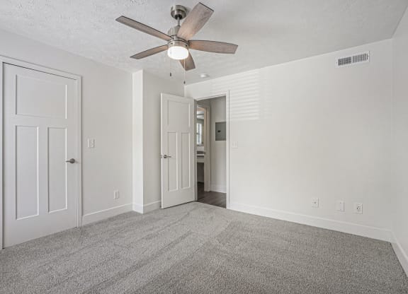 bedroom with a ceiling fan and walk in closet at The Crossings Apartments, Michigan, 49508