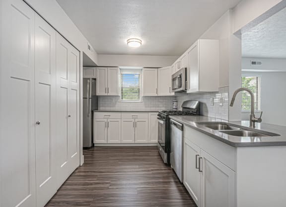 a kitchen with white cabinets and a window at The Crossings Apartments, Michigan, 49508