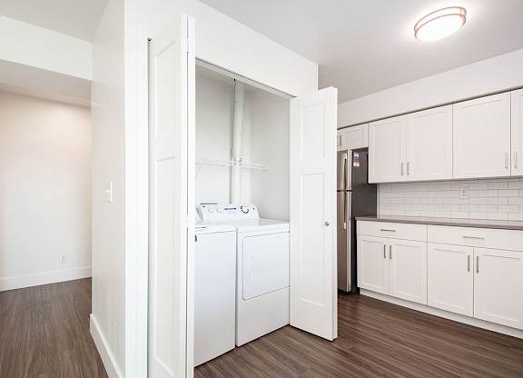 A white laundry room with a washer and dryer at The Crossings Apartments, Grand Rapids, MI, 49508