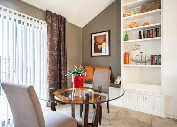A dining room with a glass table and chairs