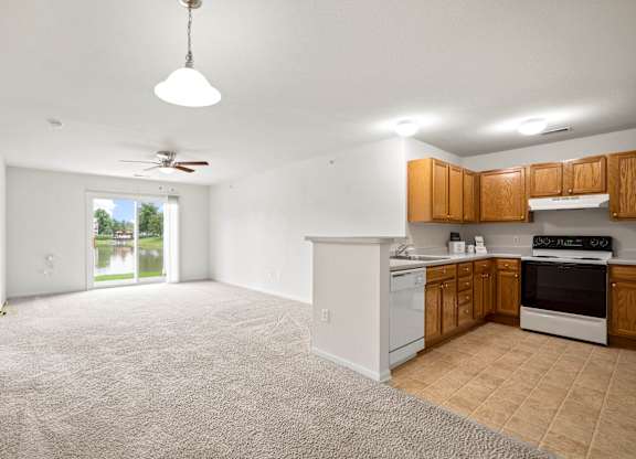 A kitchen with white appliances and wooden cabinets at Towne Lakes Apartments, Grand Chute