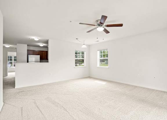 A room with a ceiling fan and carpeted floor at Towne Lakes Apartments, Grand Chute
