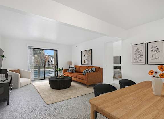 A living room with a brown sofa and a wooden table at Dupont Lakes Apartments in Fort Wayne, IN