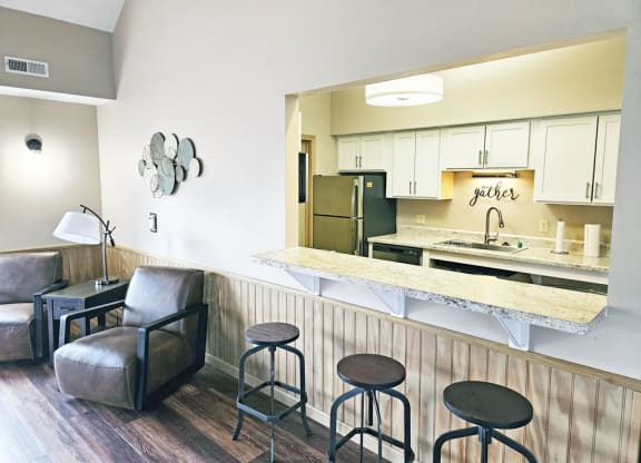 Clubhouse kitchen with a bar and stools at Dupont Lakes Apartments in Fort Wayne, IN 46825