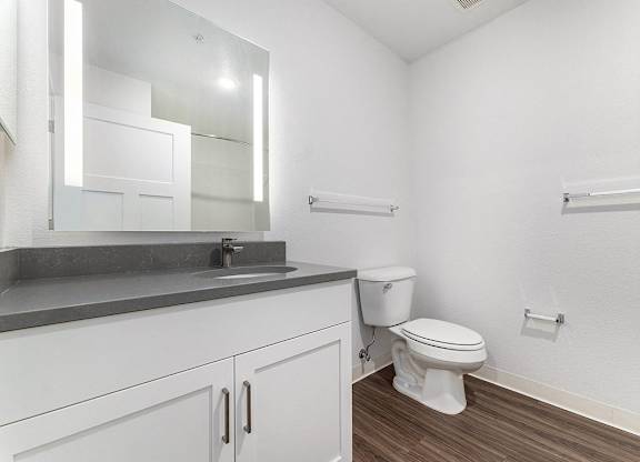 A white toilet sits next to a sink in a bathroom at Eagle Ridge Apartment Homes, Traverse City, Michigan