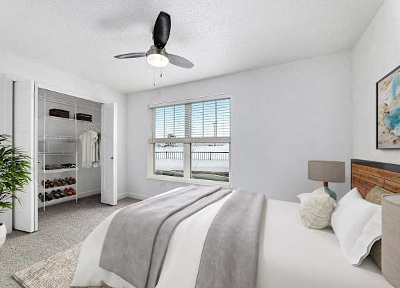 A bedroom with a large bed and a walk in closet with organizers at Eagle Ridge Apartment Homes, Traverse City, MI 49685