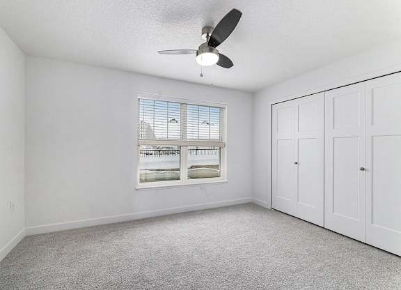 A bedroom with a ceiling fan and a window at Eagle Ridge Apartment Homes, Traverse City, Michigan
