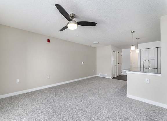 A living room with a ceiling fan and a carpeted floor at Eagle Ridge Apartment Homes, Traverse City, Michigan