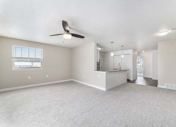 A spacious living room with a ceiling fan and a window at Eagle Ridge Apartment Homes, Traverse City, Michigan