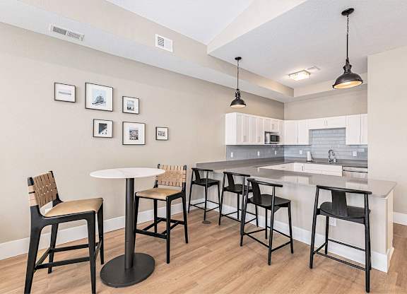 A kitchen in the community room with a bar, table and chairs at Eagle Ridge Apartment Homes,  Michigan