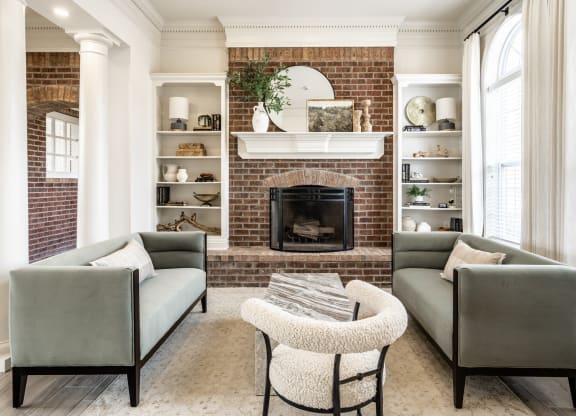 Green couches and fireplace in clubhouse at Alexandria of Carmel Apartments, Indiana