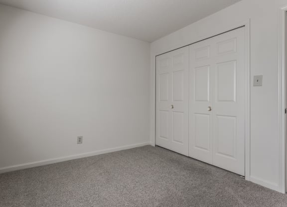 a bedroom with a closet and carpeted flooring at Bavarian Village Apartments, Indianapolis