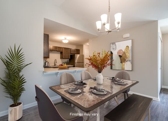 a dining room with a table and chairs and a kitchen  at Killian Lakes Apartments and Townhomes, South Carolina