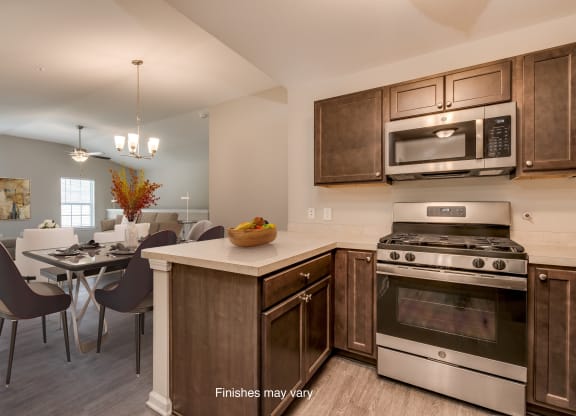 a kitchen and dining room with stainless steel appliances and wooden cabinets  at Killian Lakes Apartments and Townhomes, Columbia