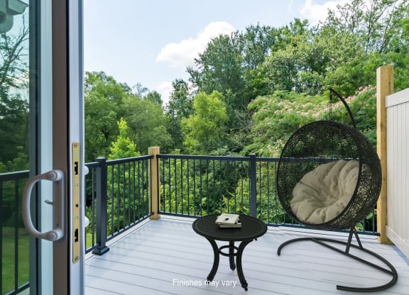 a balcony with a chair and a view of the woods  at Killian Lakes Apartments and Townhomes, Columbia, SC, 29203