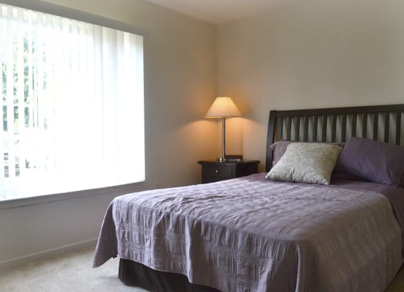 a bedroom with a bed and a window  at LakePointe Apartments, Batavia, OH, 45103
