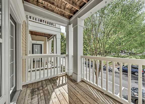 a covered porch with wood floors and white railings at Enclave Apartments, Midlothian, VA, 23114