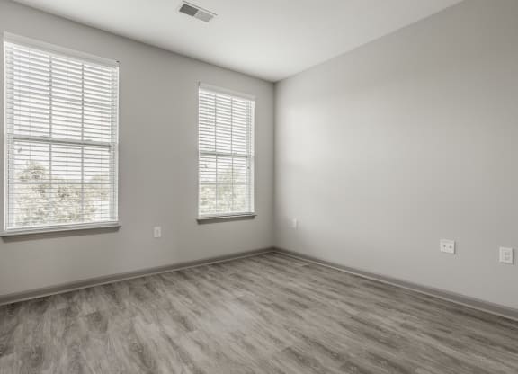 an empty room with wood flooring and two windows at The Avenue at Polaris Apartments, Columbus, OH