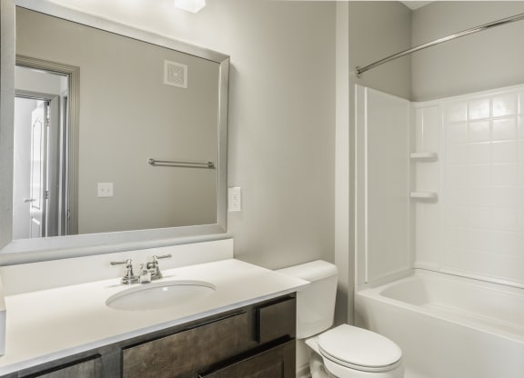 a bathroom with a sink toilet and shower and a mirror at The Avenue at Polaris Apartments, Columbus, OH