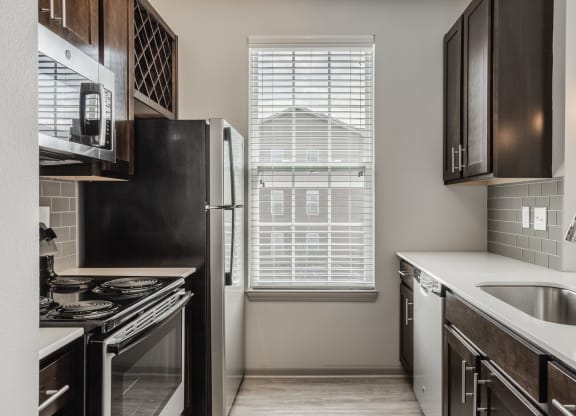 an empty kitchen with a window and a sink and refrigerator at The Avenue at Polaris Apartments, Columbus, OH