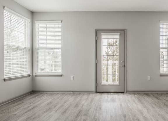 an empty room with a door and three windows at The Avenue at Polaris Apartments, Columbus, OH