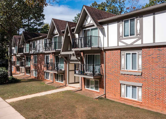 A row of red brick houses with white trim and balconies at Laurel Woods Apartments, South Carolina, 29607
