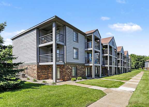 A large exterior apartment building with patios and balconies at Emerald Park Apartments in Kalamazoo, MI