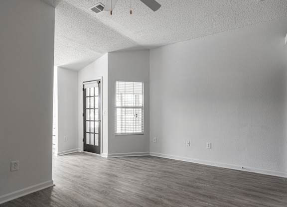 an empty living room with white walls and wood floors at Latitudes Apartments, Indianapolis, 46237
