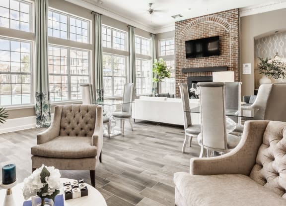 a living room with large windows and a table with chairs at The Avenue at Polaris Apartments, Columbus, OH