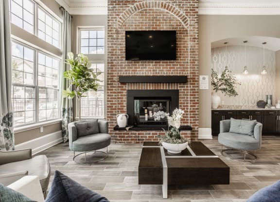 a living room with couches and a coffee table and a brick fireplace at The Avenue at Polaris Apartments, Columbus, OH
