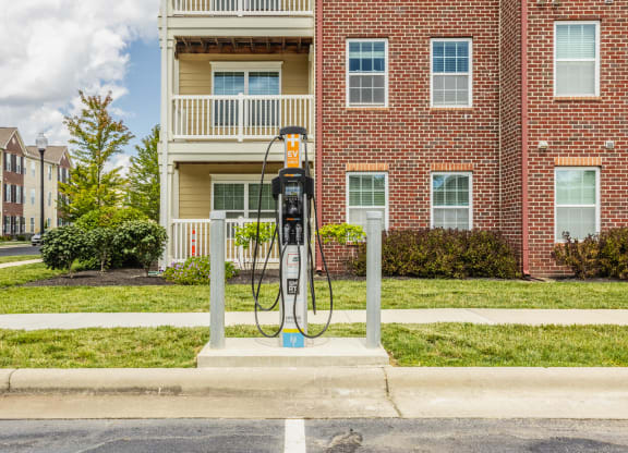 a gas pump sitting in front of a red brick building at The Avenue at Polaris Apartments, Columbus, OH