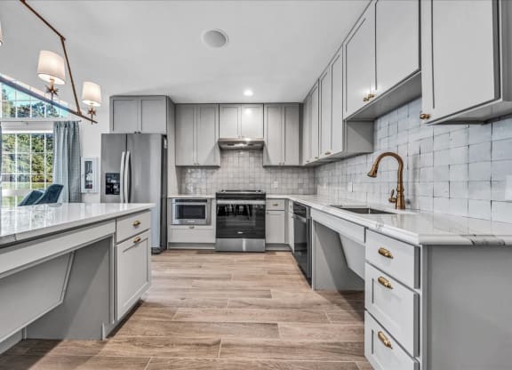 a large kitchen with white cabinets and stainless steel appliances at The Vinings Apartments in Richmond, VA