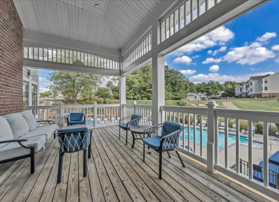 a covered porch with a pool and furniture on it at The Vinings Apartments in Richmond, VA