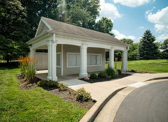 A small white house with a porch and a covered walkway.
