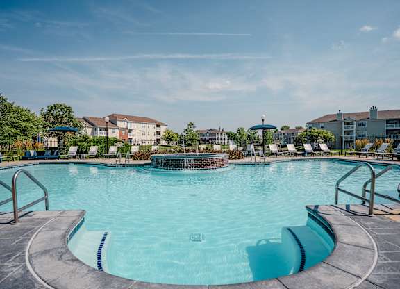 A large outdoor swimming pool with a metal railing around it.