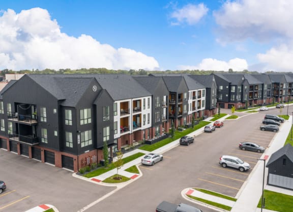 an aerial view of a row of apartment buildings in a parking lot at Uptown Square Apartments, Michigan, 48083