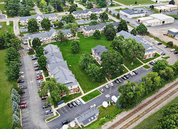 A drone view of an apartment complex with buildings and parking lots at Fairlane Apartments, Springfield, MI 49037