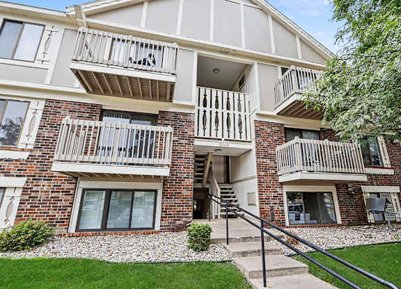 A multi-story apartment building with a balconies on the second and third floors at Fairlane Apartments, Springfield, MI 49037