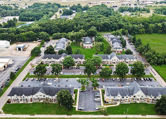 A bird's eye view of a residential area with apartment buildings and green grounds at Fairlane Apartments, Springfield, MI 49037