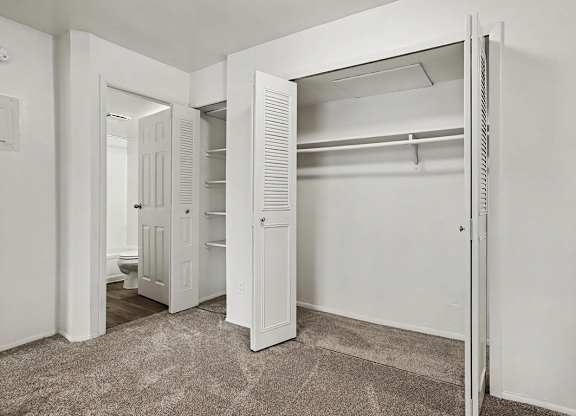 Empty bedroom with open closet and shelving at Fairlane Apartments, Springfield, Michigan