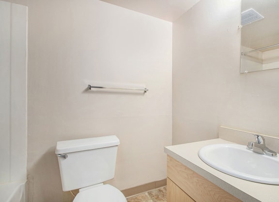 a studio bathroom with a sink toilet and a mirror at Old Farm Apartments, Elkhart, Indiana