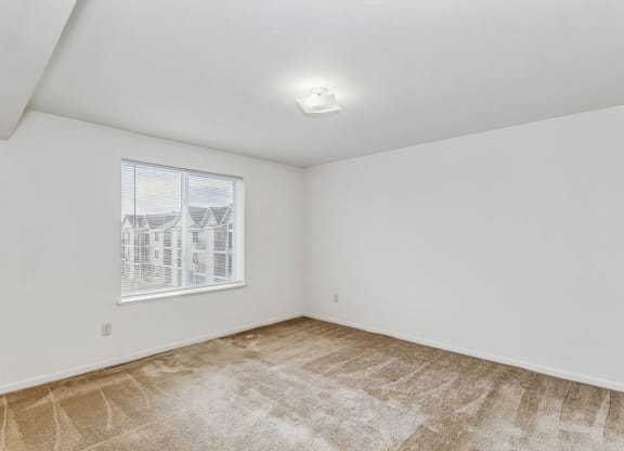 a bedroom with a window and plush carpeting at Fieldstream Apartment Homes, Ankeny, Iowa