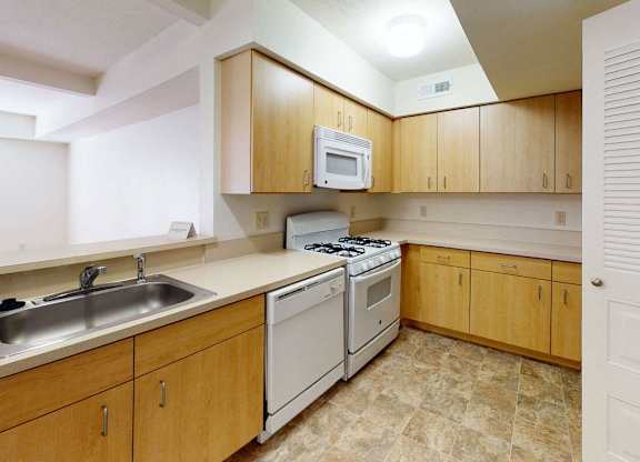 a kitchen with white appliances and a breakfast bar at Fieldstream Apartment Homes, Iowa