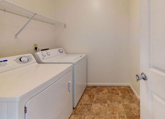 a washer and dryer in a laundry room with a door at Fieldstream Apartment Homes, Iowa