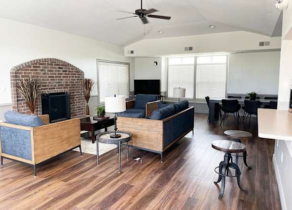 A living room with a brick fireplace and a couch at Fieldstream Apartment Homes in Ankeny, IA